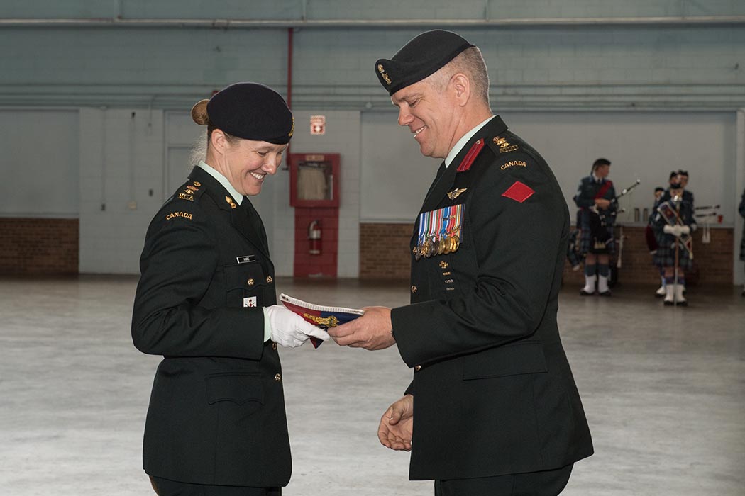 Incoming Commandant of The Royal Canadian Regiment of Artillery School (RCAS) Lieutenant-Colonel Kathy Haire accepts her Commandant’s pennant, which signifies her taking command of the RCAS, from Colonel John Errington, Commander of the Combat Training Centr,e during the Change of Command ceremony on June 21, 2019 at 5th Canadian Division Support Base Gagetown, Oromocto, New Brunswick. Photo: Corporal Geneviève Lapointe, Combat Training Centre. ©2019 DND/MDN Canada.